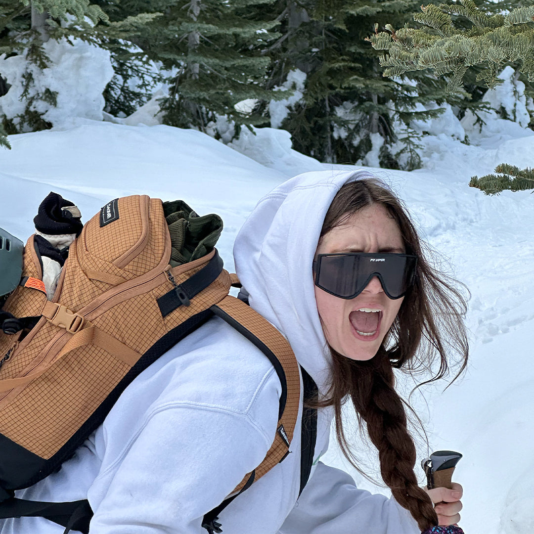 woman with her mouth open while skiing wearing black sunglasses - lifestyle