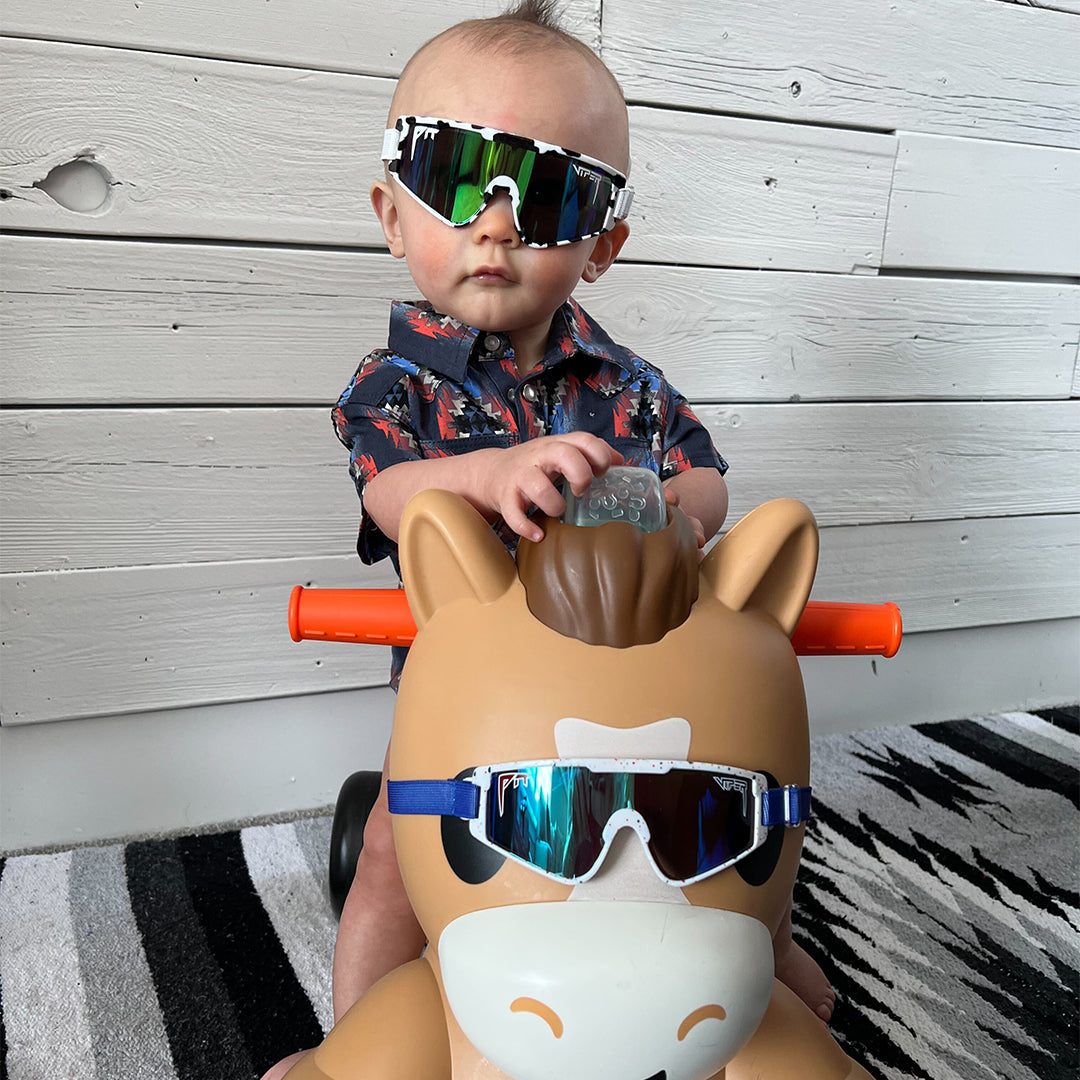 baby boy on a toy horse wearing cowabunga baby vipes - lifestyle